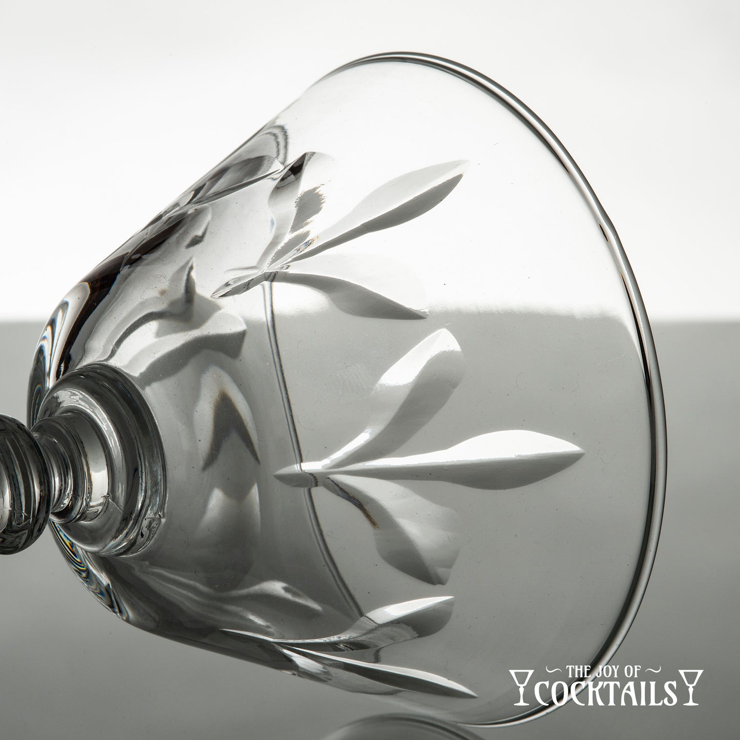 Rock Sharpe Fleur de Lis cocktail glass on a reflective surface with a white background